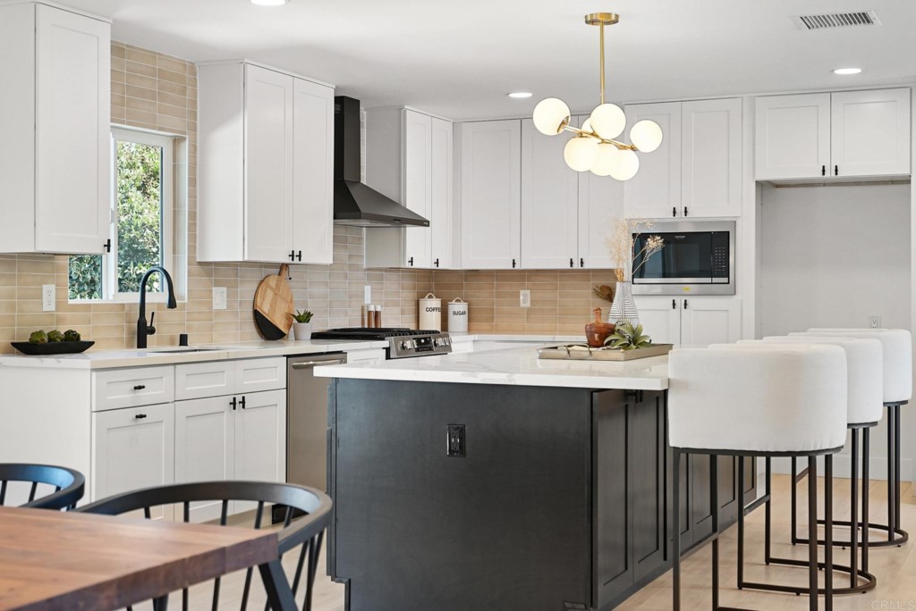 6125 Laport Street La Mesa, CA 91942 - Photo 3 of 32 a kitchen with a table chairs sink and cabinets