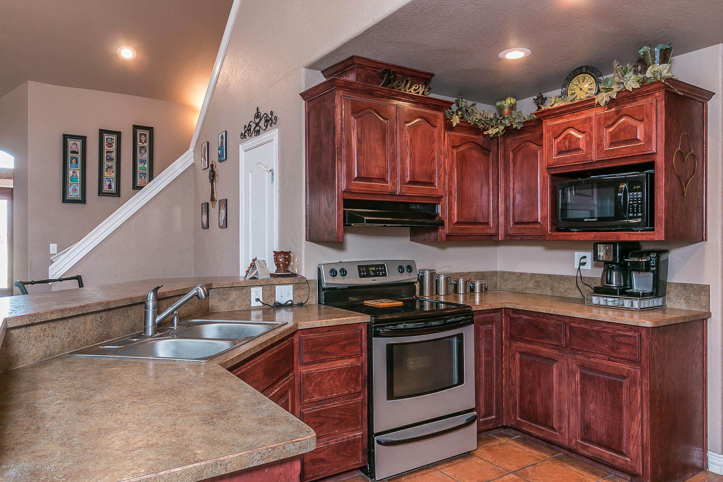 5301 Pleasant Court Amarillo, TX 79110 - Photo 8 of 28 a kitchen with granite countertop a sink a stove top oven and cabinetry