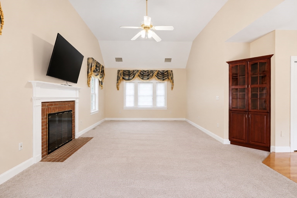 61 Indian Head Road Framingham, MA 01701 - Photo 38 of 42 an empty room with windows fireplace and a chandelier fan