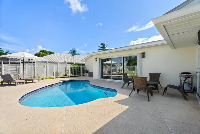 a view of a house with swimming pool and sitting area
