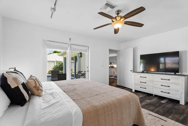a bedroom with a bed a flat screen tv and a chandelier