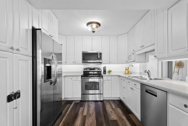a kitchen with cabinets stainless steel appliances and a counter space