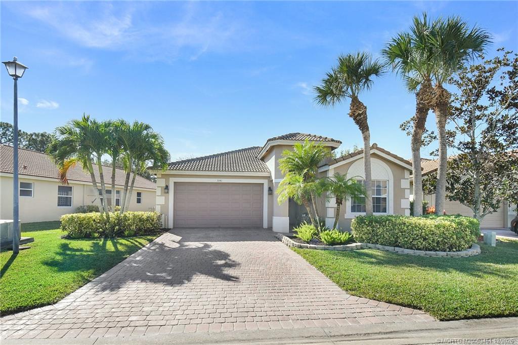 3141 Southwest Porpoise Circle Stuart, FL 34997 - Photo 1 of 45 a front view of a house with garden