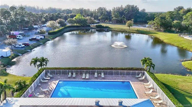 a view of swimming pool with outdoor seating and lake view