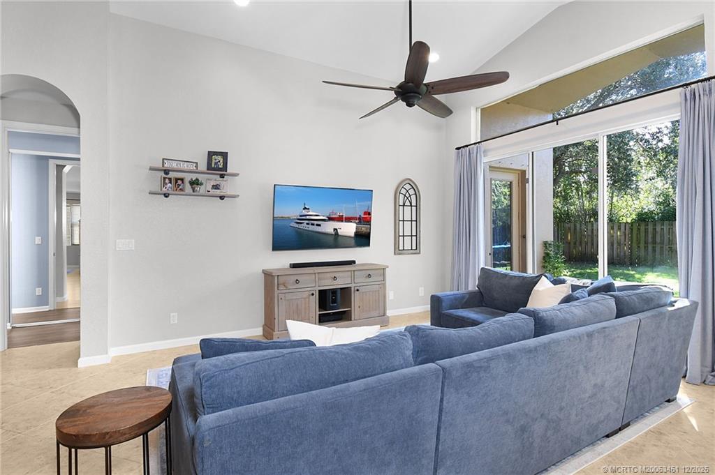 3141 Southwest Porpoise Circle Stuart, FL 34997 - Photo 4 of 45 a living room with furniture a fireplace and a flat screen tv