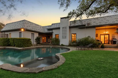 a view of a house with pool yard and a chairs