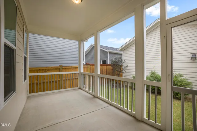 a view of an empty room and chandelier fan
