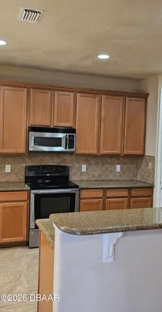 a kitchen with granite countertop a refrigerator and a sink