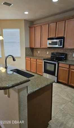 a kitchen with a sink a stove cabinets and a counter top space