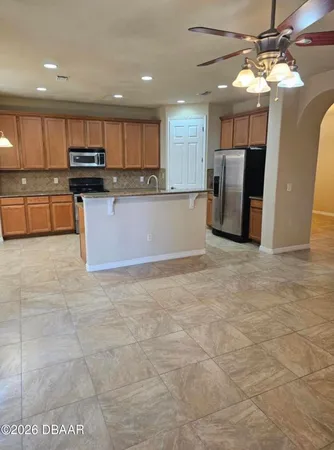 an empty room with a chandelier fan and windows