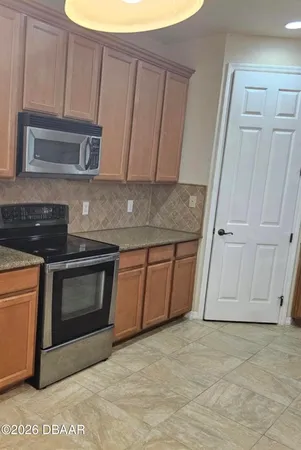 a view of a room with a chandelier fan and wooden floor