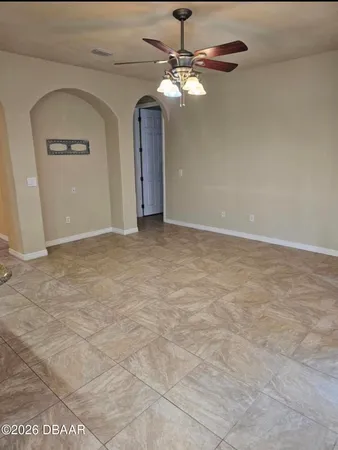 a view of an empty room with a chandelier fan