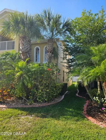 a view of a house with backyard and a tree