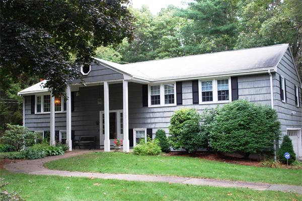 a backyard of a house with potted plants and large tree