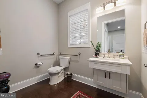 a spacious bedroom with a bed a dresser and wooden floor