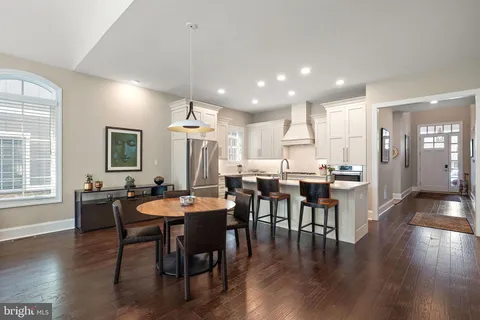 a kitchen with a sink a stove a refrigerator and white cabinets with wooden floor