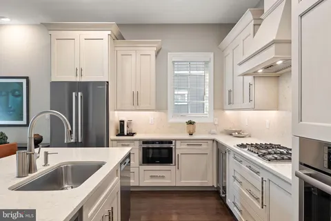 a kitchen with cabinets stainless steel appliances and a window