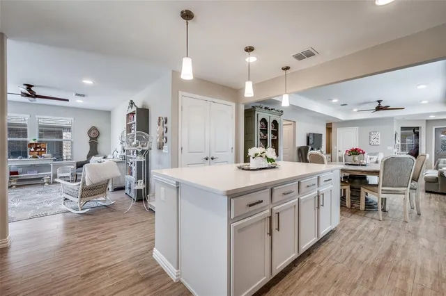 a large kitchen with kitchen island a sink table and chairs