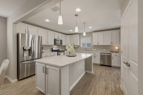 a kitchen with kitchen island a sink stainless steel appliances and cabinets