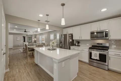 a large kitchen with kitchen island a large island in it