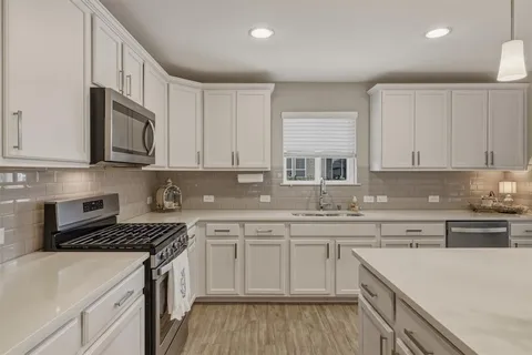 a kitchen with cabinets appliances a sink and a counter space