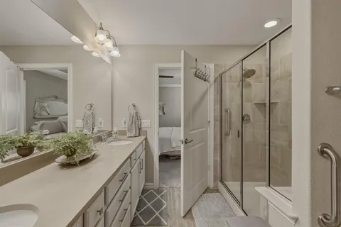 a bathroom with a double vanity sink a toilet and shower