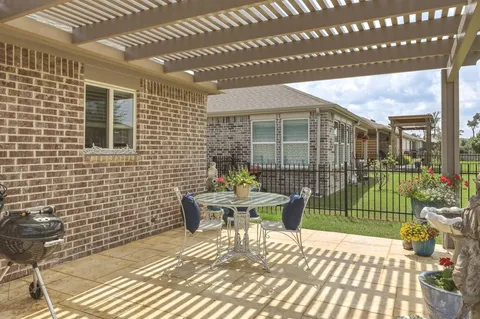 a view of a patio with a table and chairs and floor to ceiling window