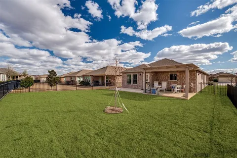 a view of a house with a big yard and a large tree