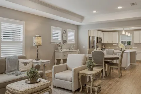a living room with furniture kitchen view and a large window