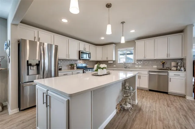 a kitchen with a refrigerator a sink and cabinets
