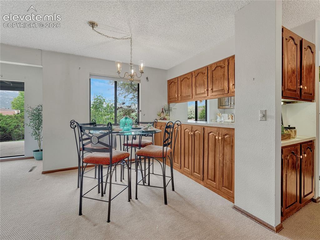 1146 Fontmore Road, Unit A Colorado Springs, CO 80904 - Photo 10 of 24 a dining room with furniture a chandelier and window