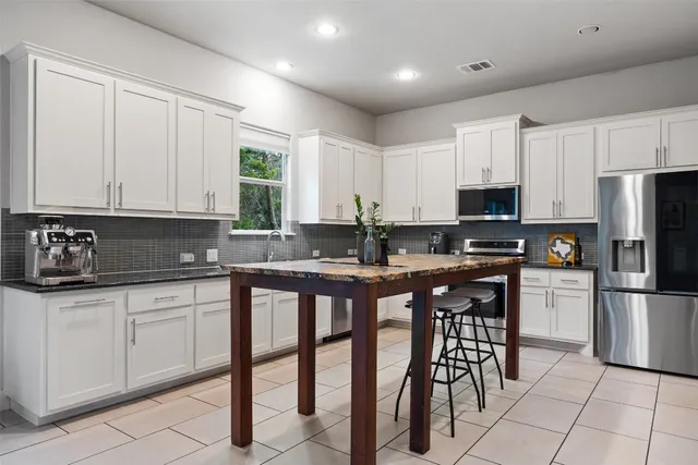 a kitchen with appliances a sink and cabinets