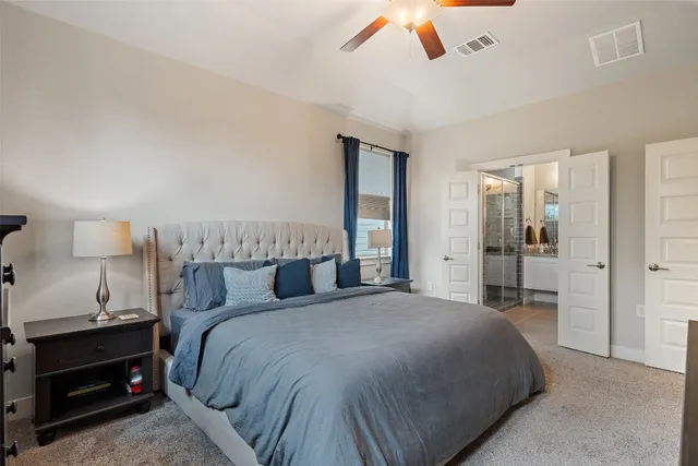 a bedroom with a large bed and a chandelier