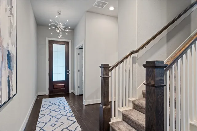 a view of a hallway with wooden floor and staircase