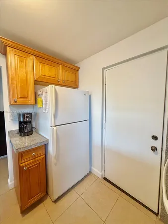 a white refrigerator freezer and a stove in a kitchen