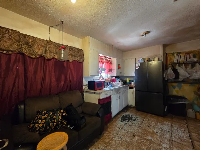 a kitchen with refrigerator and cabinets