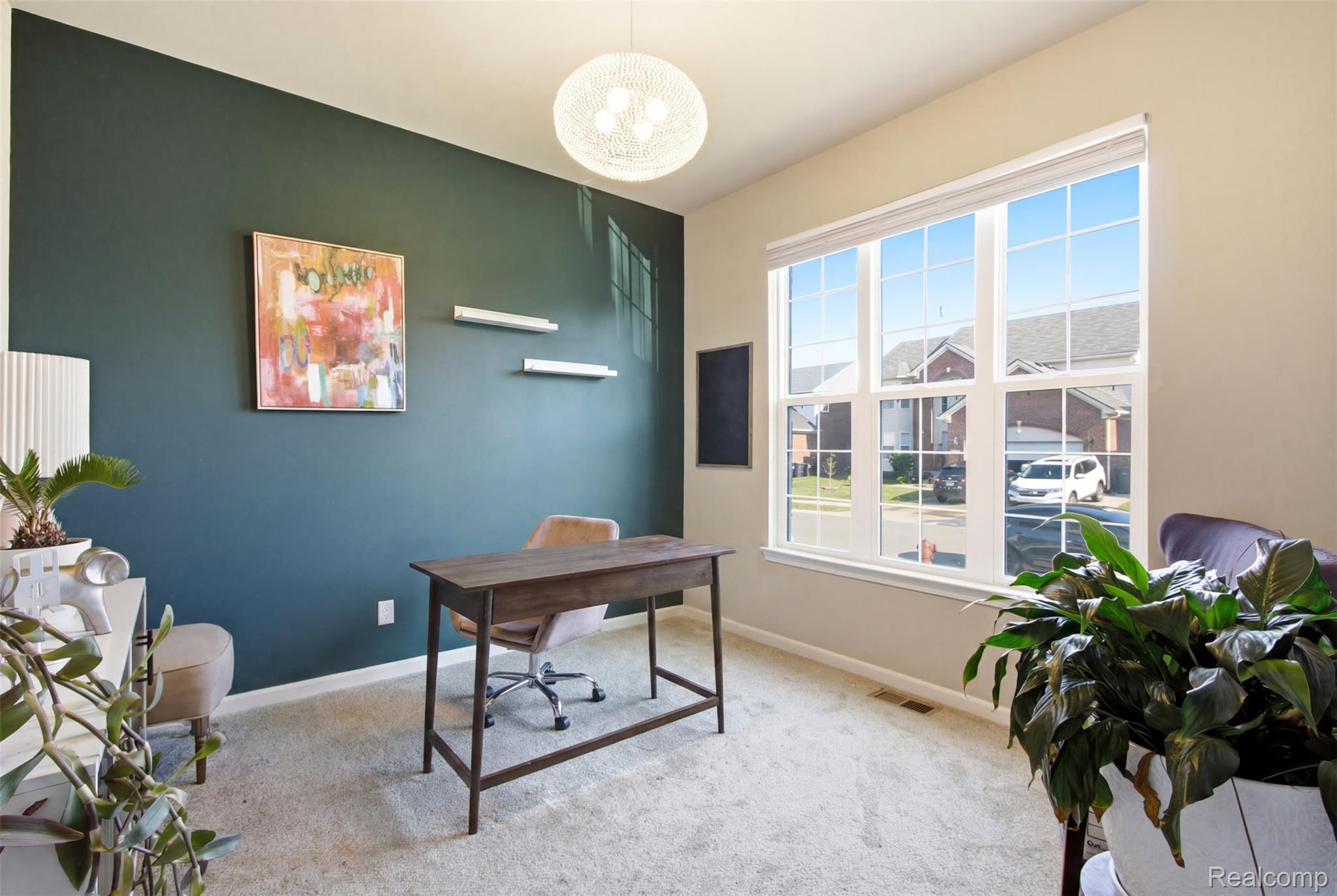 5085 Ridge Lane Warren, MI 48092 - Photo 4 of 29 Bright room featuring a large multi-pane window, light-colored carpet flooring, a dark accent wall, and a woven pendant light fixture