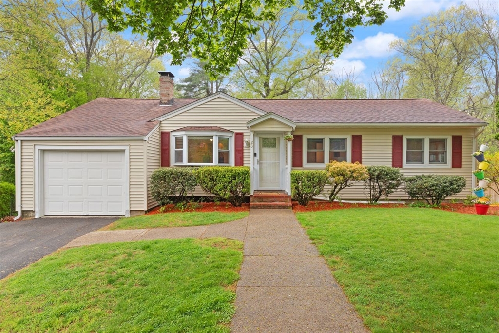 a front view of a house with a garden and yard