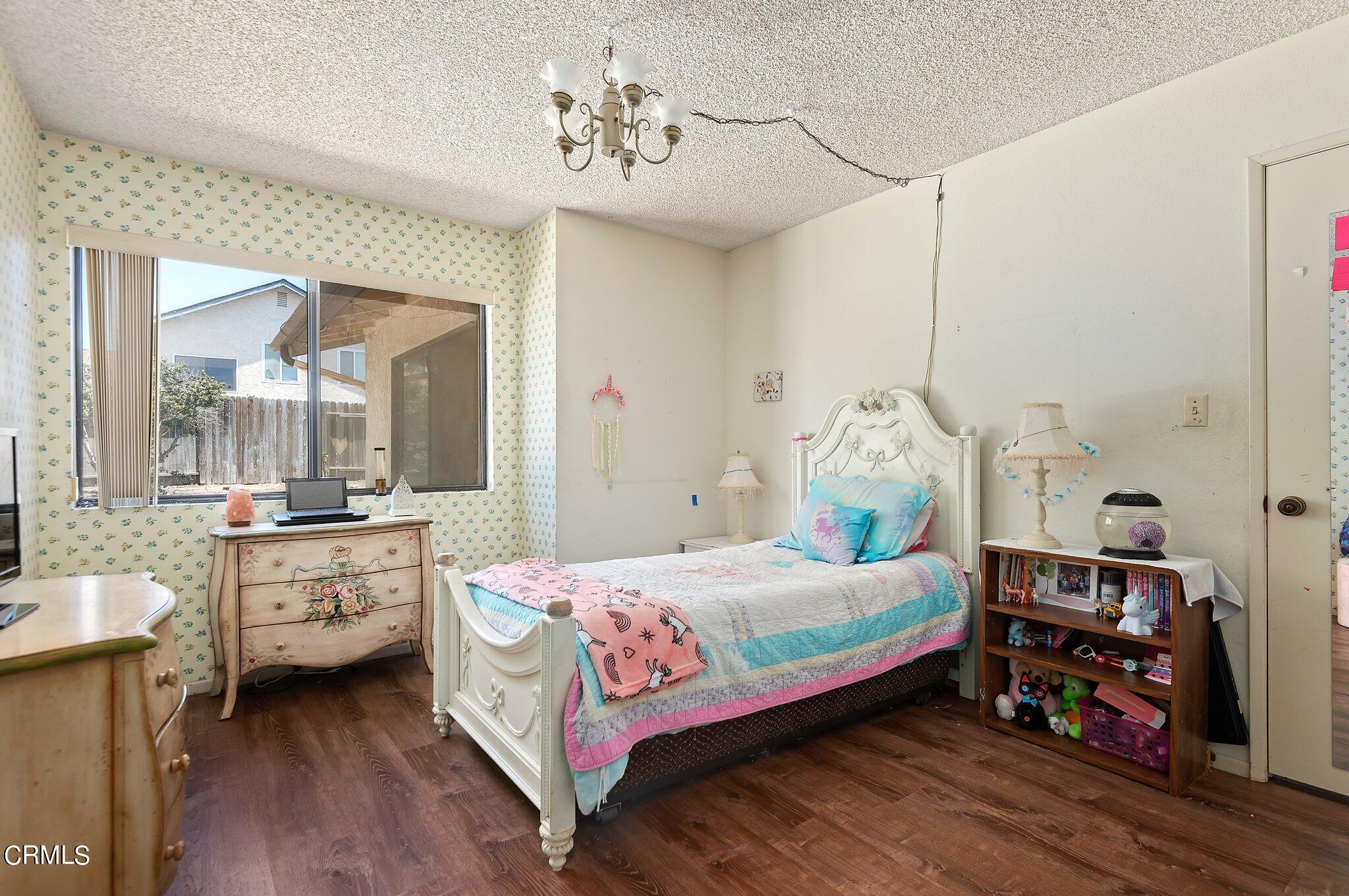 3041 Jacktar Avenue Oxnard, CA 93035 - Photo 15 of 19 a bedroom with a bed and a chandelier