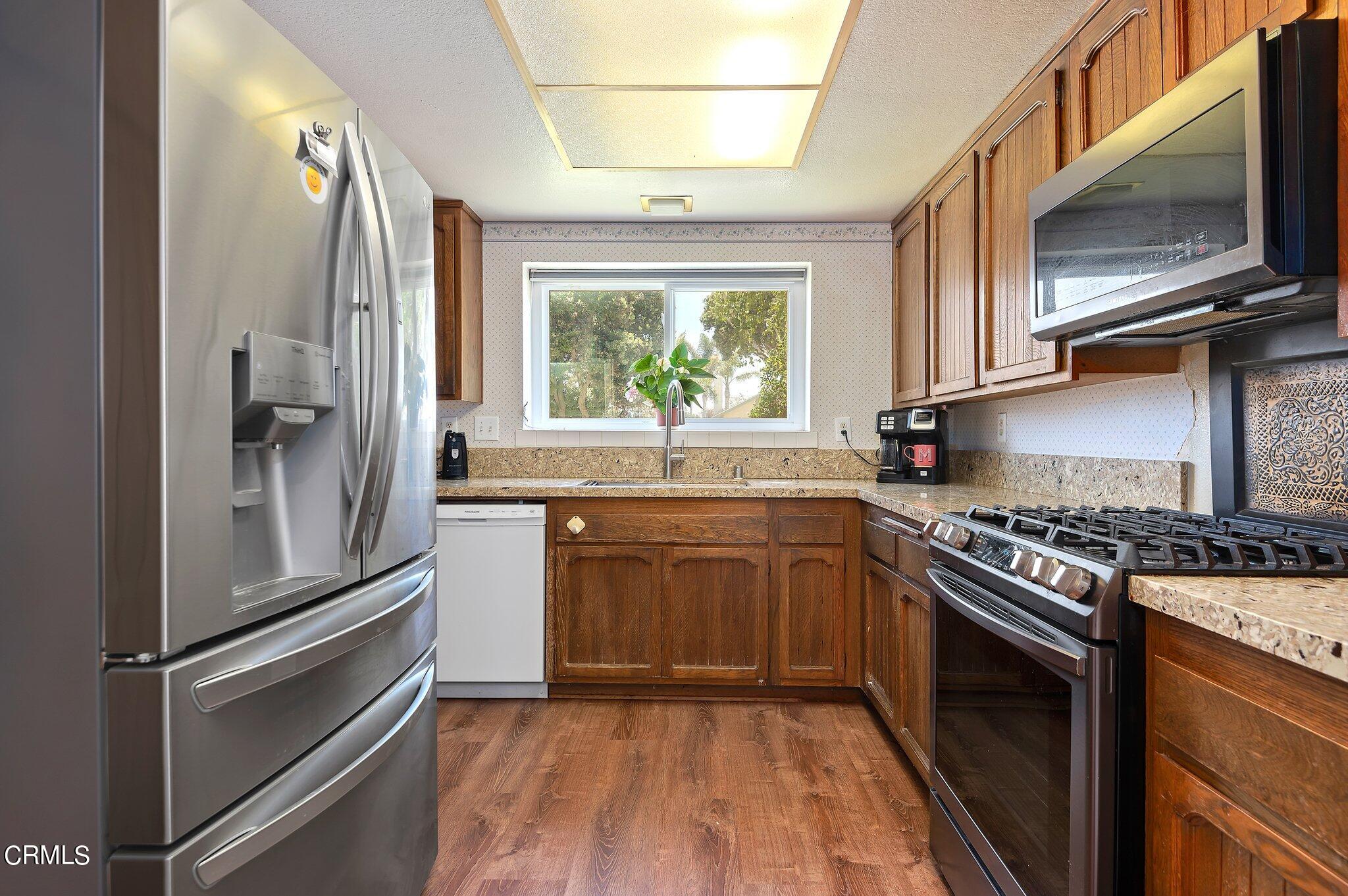 3041 Jacktar Avenue Oxnard, CA 93035 - Photo 8 of 19 a kitchen with granite countertop stainless steel appliances a stove sink and refrigerator