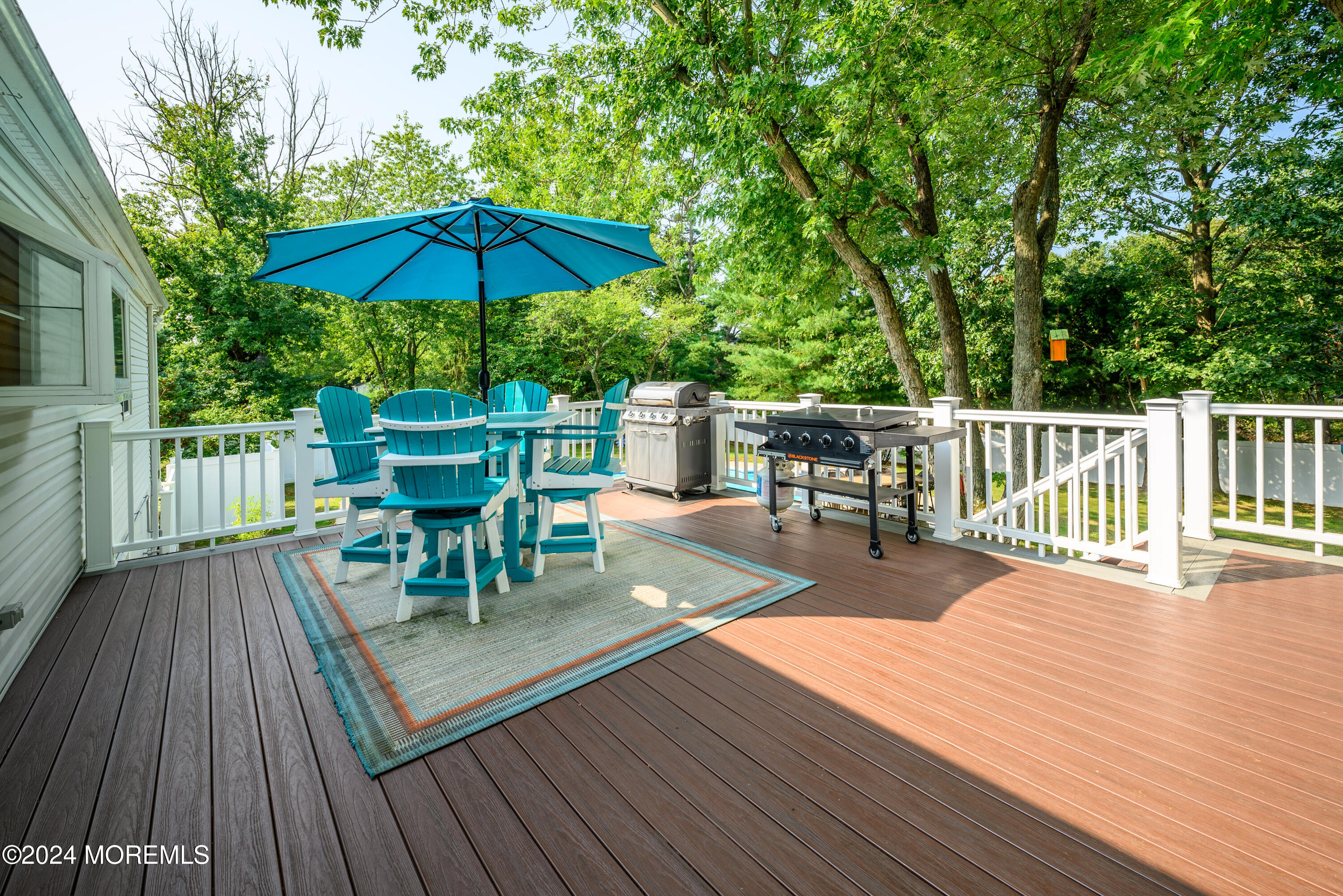 28 Chestnut Hill Road Howell, NJ 07731 - Photo 35 of 48 a view of a roof deck with table and chairs under an umbrella with wooden floor