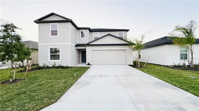 a front view of a house with a yard and garage