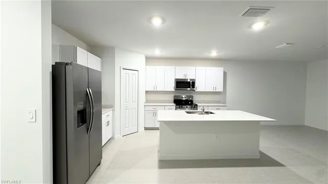 a kitchen with stainless steel appliances a refrigerator sink and microwave