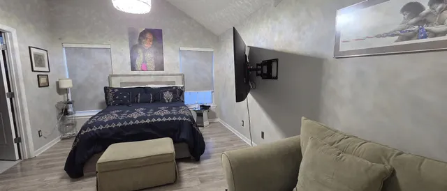 a bedroom with a bed and wooden floor