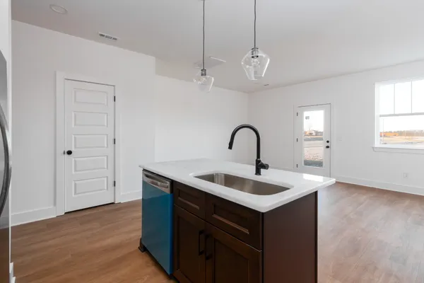 a kitchen with a sink and a wooden floor