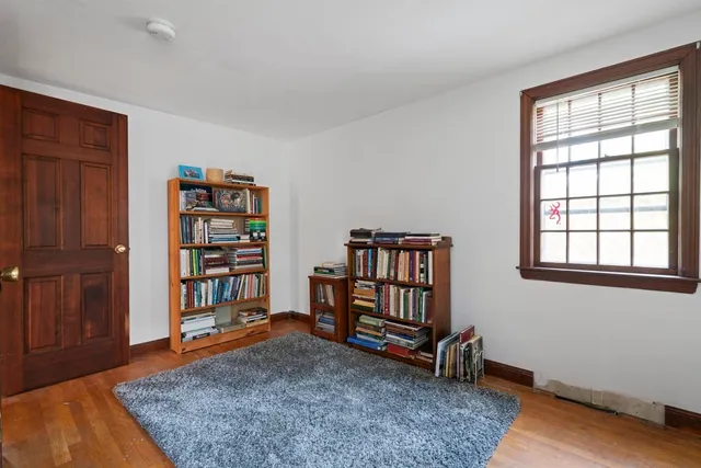 a living room with a bookshelf and a wooden floor