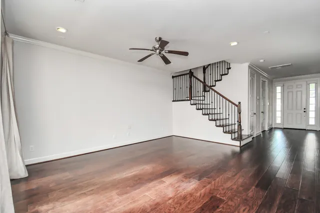 a view of a livingroom with wooden floor and a ceiling fan
