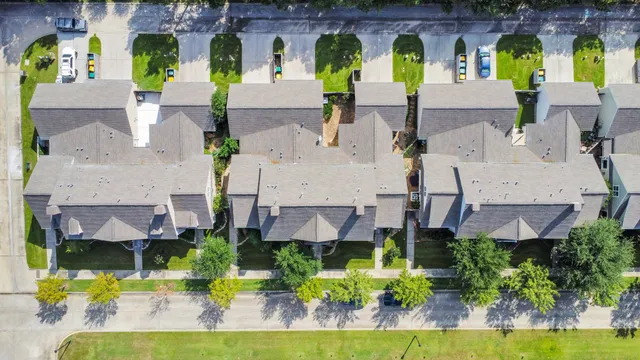 an aerial view of multiple houses with a yard