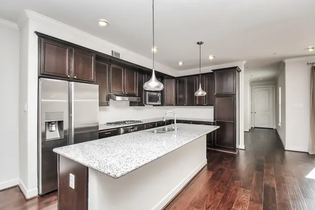 a large kitchen with stainless steel appliances granite countertop a sink stove and refrigerator