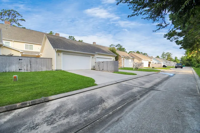 a view of a house with a yard and street